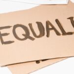 The word Equality painted on a piece of cardboard