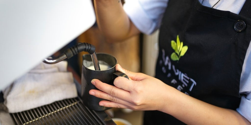 Close up of barista making a latte