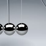 Five silver balls hanging next to each other, bumping the fifth one forward.