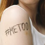 Close up of "#Me Too" written on a young woman's bare arm.
