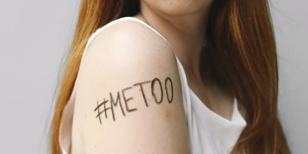 Close up of "#Me Too" written on a young woman's bare arm. 