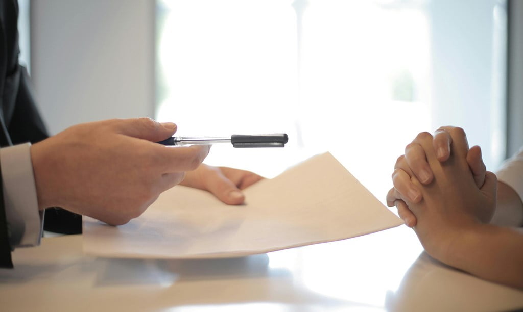 businessman giving contract to woman to sign