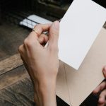View of someone's hands pulling a note out of an envelope.