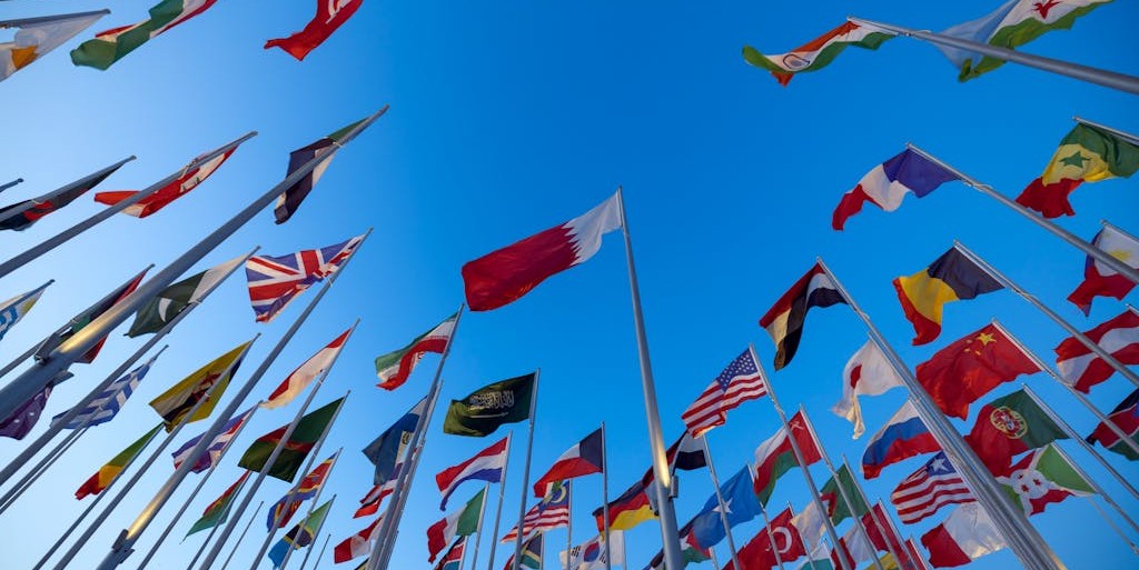 Low Angle Shot of Flags on the Background of a Clear Blue Sky