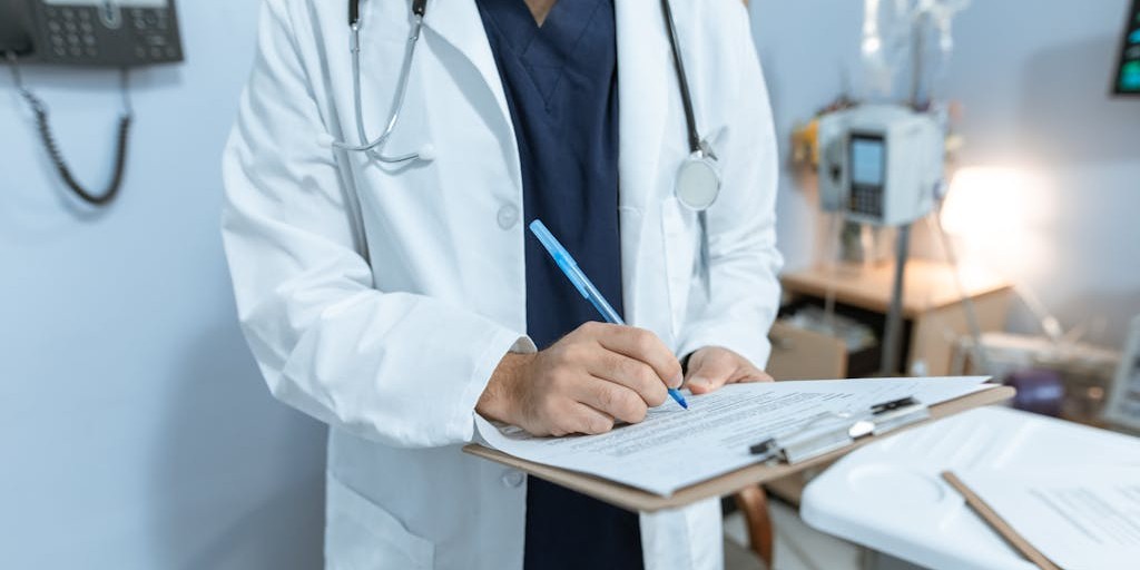 Doctor writing on a medical chart