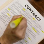 Hand highlighting document labelled contract